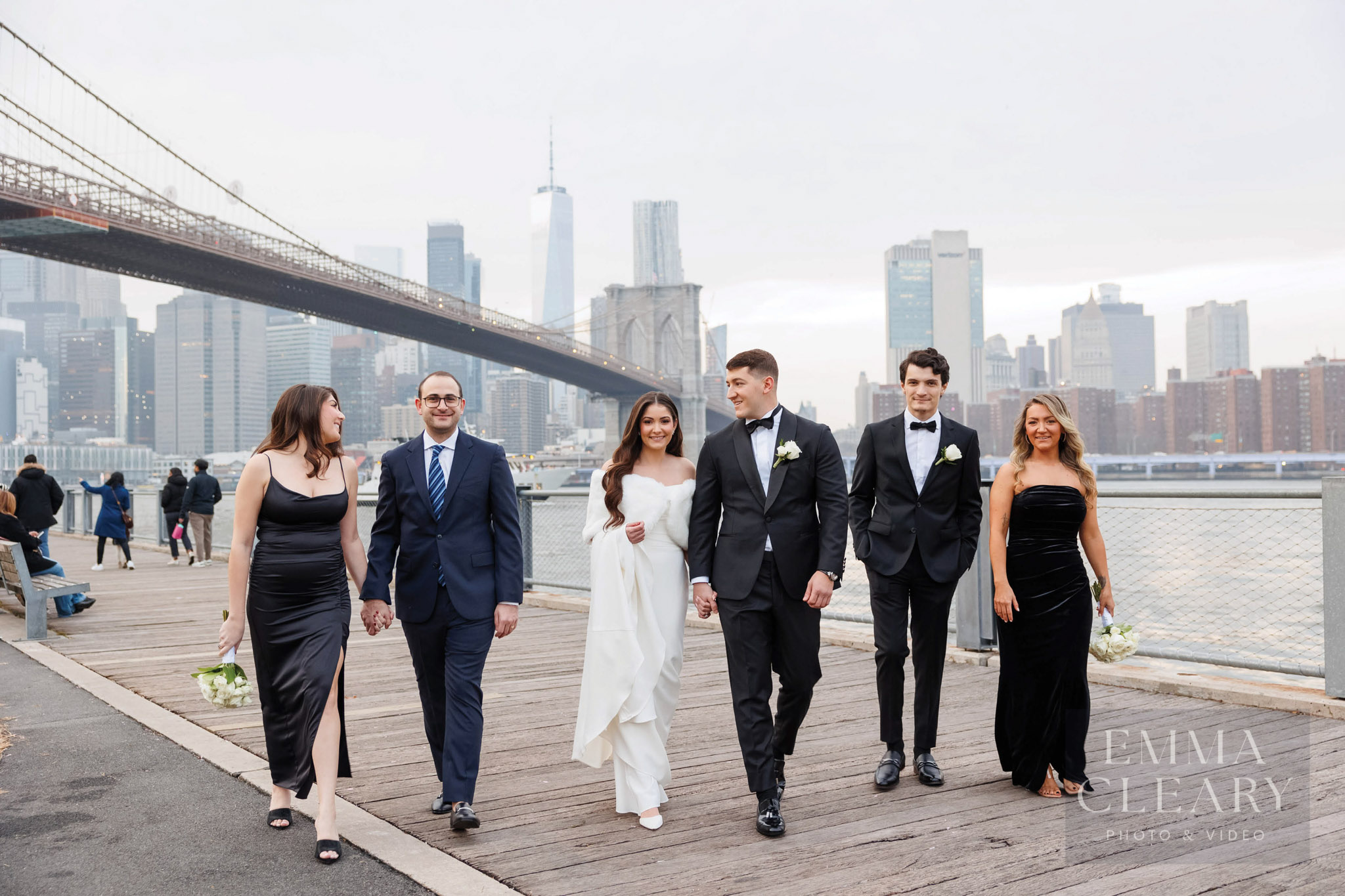 Groomsmen and bridesmaids walk near Brooklyn Bridge